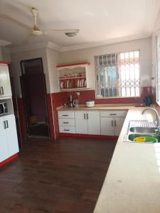 a kitchen with white cabinets and a sink at jetfastventure in Accra