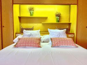 un grande letto bianco con due cuscini sopra di Casa Rural Hípica Mas Paguina a L'Estartit