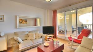 a living room with a couch and a tv at Residencial Playa Sol III in Denia