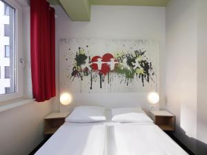 a bedroom with a white bed and a red curtain at B&B HOTEL Berlin-Potsdamer Platz in Berlin