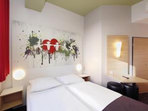 a hotel room with a bed and a painting on the wall at B&B HOTEL Berlin-Potsdamer Platz in Berlin