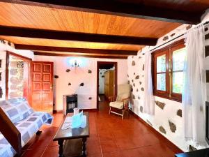 sala de estar con sofá y chimenea en Casa rural con 2 dormitorios con barbacoa y preciosa vista en Mocanal