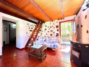 sala de estar con sofá y mesa en Casa rural con 2 dormitorios con barbacoa y preciosa vista en Mocanal