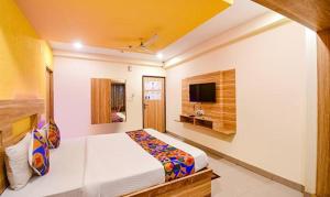 pokój hotelowy z łóżkiem i telewizorem w obiekcie FabHotel Sai Jagannath Residency w mieście Khandagiri