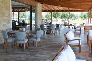 un restaurante con mesas y sillas y personas sentadas en mesas en JURA HOTELS ALTINOLUK THERMAL, en Avcılar