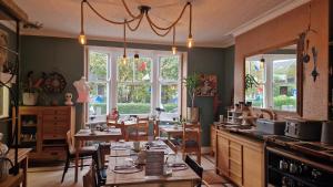 a kitchen with a table and chairs and windows at The Ocean Guest House in Weymouth