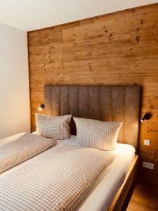 2 łóżka w sypialni z drewnianym zagłówkiem w obiekcie FourElements Grand Chalet w mieście Blankenburg