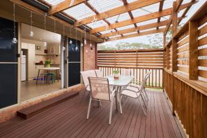 a patio with a table and chairs on a deck at Breeza Haven - Your Home Away From Home in Kingston