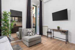 Una sala de estar con una silla y un televisor. en Apartments & rooms ONE WORLD, en Rijeka