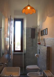 La salle de bains est pourvue d'un lavabo, de toilettes et d'une fenêtre. dans l'établissement Appartamento via Grandi - Free Gated Parking - 5 minutes from Center, à Lucques
