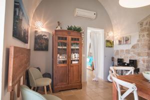 ポリニャーノ・ア・マーレにあるTrulli Dimore - Casa Fusellaのリビングルーム(木製のキャビネット、テーブル付)