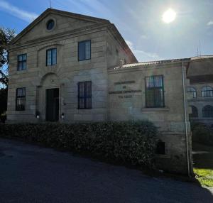 un vieux bâtiment en pierre avec le soleil derrière lui dans l'établissement Casa Diocesana VIA LUCIS, à Saint-Jacques-de-Compostelle