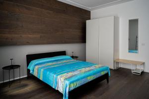 een slaapkamer met een bed en een houten muur bij Corso 66 Luxury Apartment in Salerno