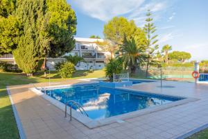 a swimming pool in a yard with trees and a house at Casa Oliveira - Algarve in Porches