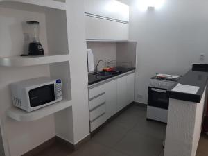 a small kitchen with a microwave and a sink at Apartamento 1011 in Goiânia
