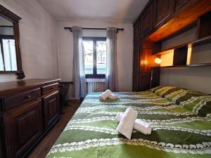 um quarto com uma cama grande e toalhas em Hostdomus - Gran Roche em Sestriere