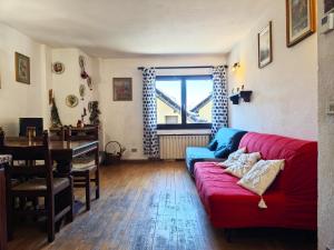 a living room with a red couch and a table at Hostdomus - Gran Roche in Sestriere