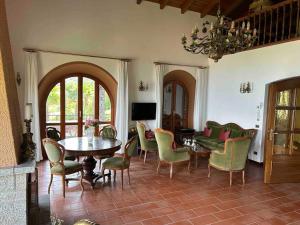 een woonkamer met een tafel en stoelen bij Villa Casa Camelia in Traumlage in San Bartolomeo