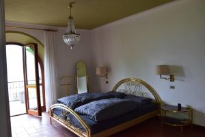 Un dormitorio con una cama en una habitación con ventana. en Villa Casa Camelia in Traumlage, en San Bartolomeo