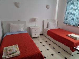 a room with two beds and a table with a lamp at Casa das Flores in Albufeira