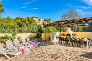un patio con sillas y una mesa y una cocina en Villa Enzo - PlusHolidays, en Moraira