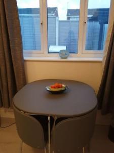 a bowl of fruit on a table in front of a window at Self contained annexe in Kidderminster