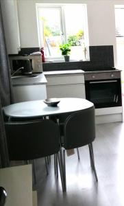 a kitchen with a table and two black chairs at Self contained annexe in Kidderminster