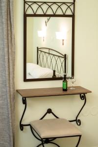 a mirror on a wall with a shelf and a chair at Konstantinos Hotel & Apartments 2 in Nydri