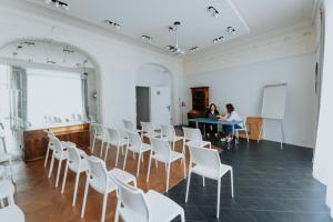 two women sitting at a table in a room with white chairs at Hotel Albert 1er in Toulouse