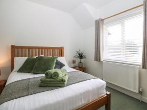 a bedroom with a bed with a towel on it at 1 Matrons Cottages in Littlehampton