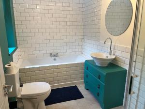 y baño con aseo, lavabo y bañera. en King Street Apartments en Southport