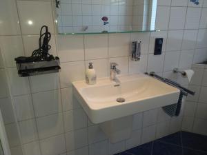een badkamer met een witte wastafel en een spiegel bij Mucki´s Ferienwohnung in Bad Zwischenahn