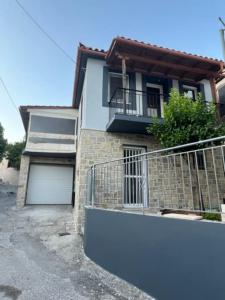 a house with a balcony and a garage at Lemon Tree in Agios Vlasios