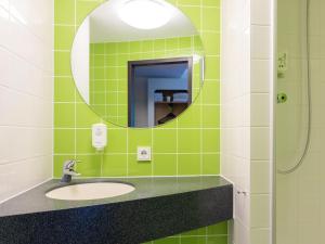 La salle de bains est pourvue d'un lavabo et d'un miroir. dans l'établissement B&B HOTEL Dortmund-Messe, à Dortmund