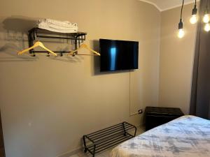 ein Schlafzimmer mit einem Bett und einem TV an der Wand in der Unterkunft PETITE MAISON in Lanciano