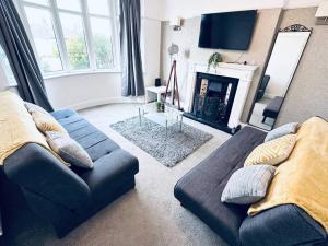 a living room with a blue couch and a fireplace at Comfy House Near The City Centre in Nottingham