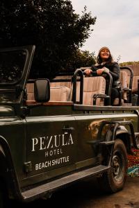 a woman sitting in the back of a green truck at Pezula Nature Retreat in Knysna