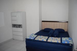 een kleine slaapkamer met een blauw bed en een kast bij Rumah Inyiak Aguang in Baso