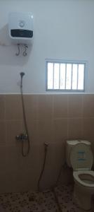 een badkamer met een toilet en een raam bij Rumah Inyiak Aguang in Baso
