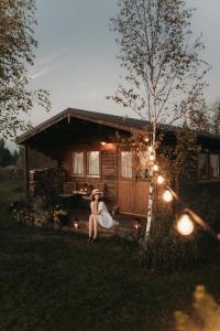 a couple sitting on a bench in front of a cabin at Ambercoast in Jūrmala