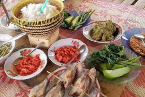 uma mesa com pratos de comida numa mesa em Rumah Inyiak Aguang em Baso