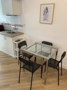 cocina con mesa de cristal y sillas en una habitación en FEDRIANI Bright and cosy apartment, en Sevilla
