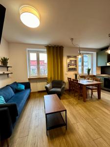 uma sala de estar com um sofá azul e uma mesa em Jazz Apartament Częstochowa Centrum 2-bedroom em Czestochowa