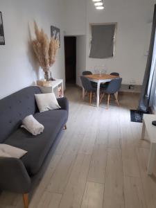 a living room with a couch and a table at Charmante maison dans le Gers, proche lac et centre-ville in LʼIsle-Jourdain