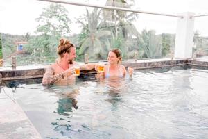 dos personas bebiendo vino en una piscina en Emerald Bay Resort Mirissa en Mirissa