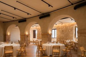 une salle de banquet avec des tables et des chaises dans un bâtiment dans l'établissement Castilla Termal Brihuega, à Brihuega