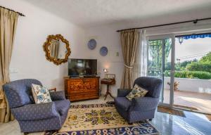 een woonkamer met 2 stoelen en een televisie bij Casa Rosfra in Carvoeiro