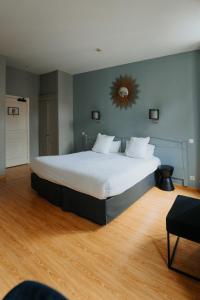 ein Schlafzimmer mit einem großen Bett und einem Spiegel an der Wand in der Unterkunft Hotel Albert 1er in Toulouse