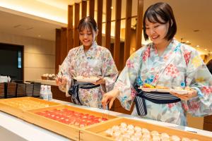 dwie kobiety stojące w kuchni przygotowujące jedzenie w obiekcie KAMENOI HOTEL Okunikko w mieście Nikko