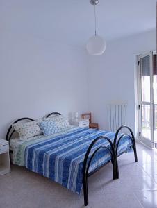 1 dormitorio con 1 cama con edredón azul en casa LULU due minuti dal mare en Ardore Marina